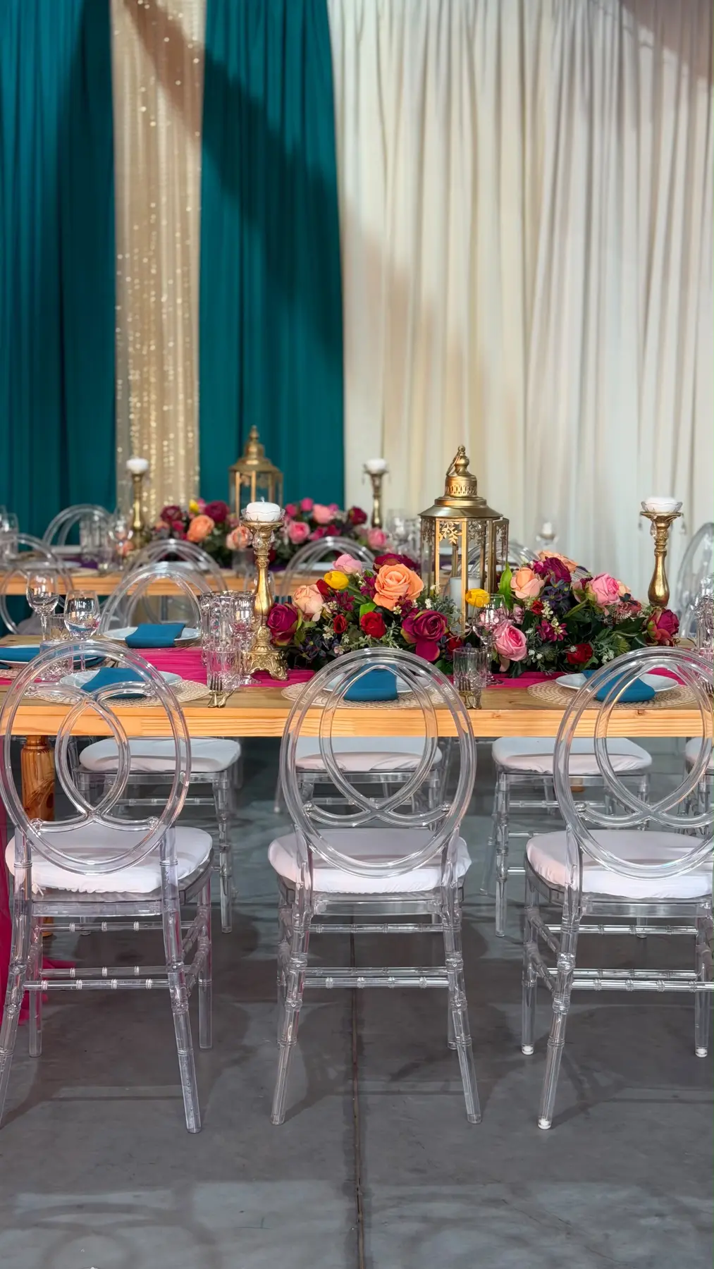 Jewel-toned banquet setting with clear chairs by Khan Events
